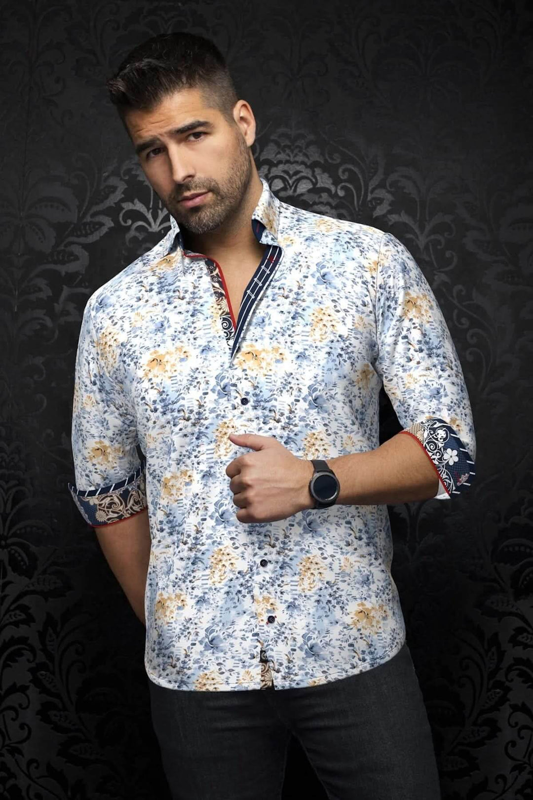 Homme portant une chemise à imprimé floral aux teintes douces, avec des détails contrastants au col et aux poignets.