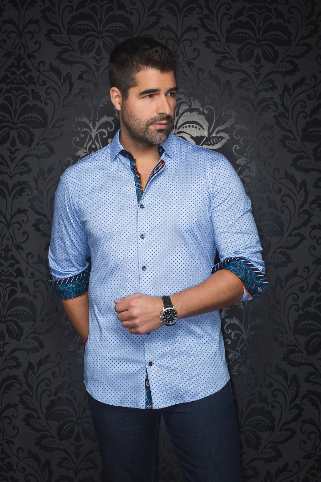 Homme portant une chemise élégante à motif discret avec col contrastant et poignets doublés.