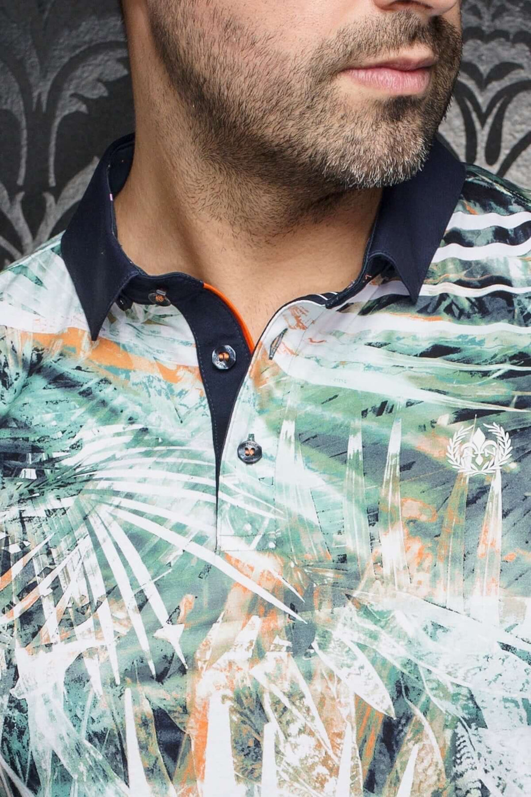 Polo Amazonia à motifs feuillus, col contrastant marine, idéal pour journées ensoleillées.