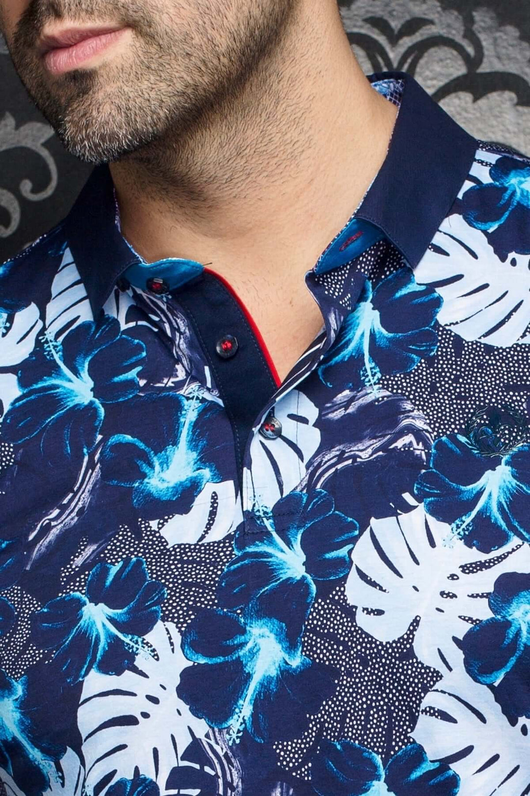Polo Campari à motifs tropicaux bleutés avec col contrastant bleue marine et détails en rouge.