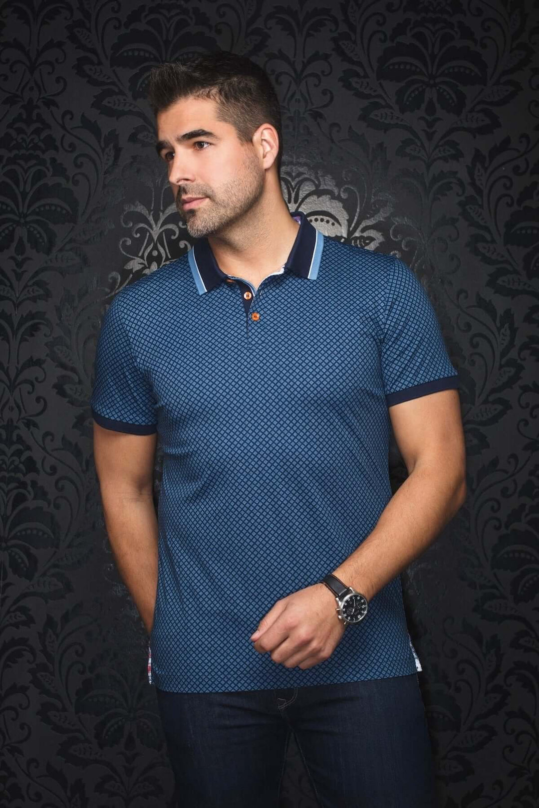 Homme portant un polo géométrique bleu marine avec des détails contrastants et un col à liseré bleu clair.
