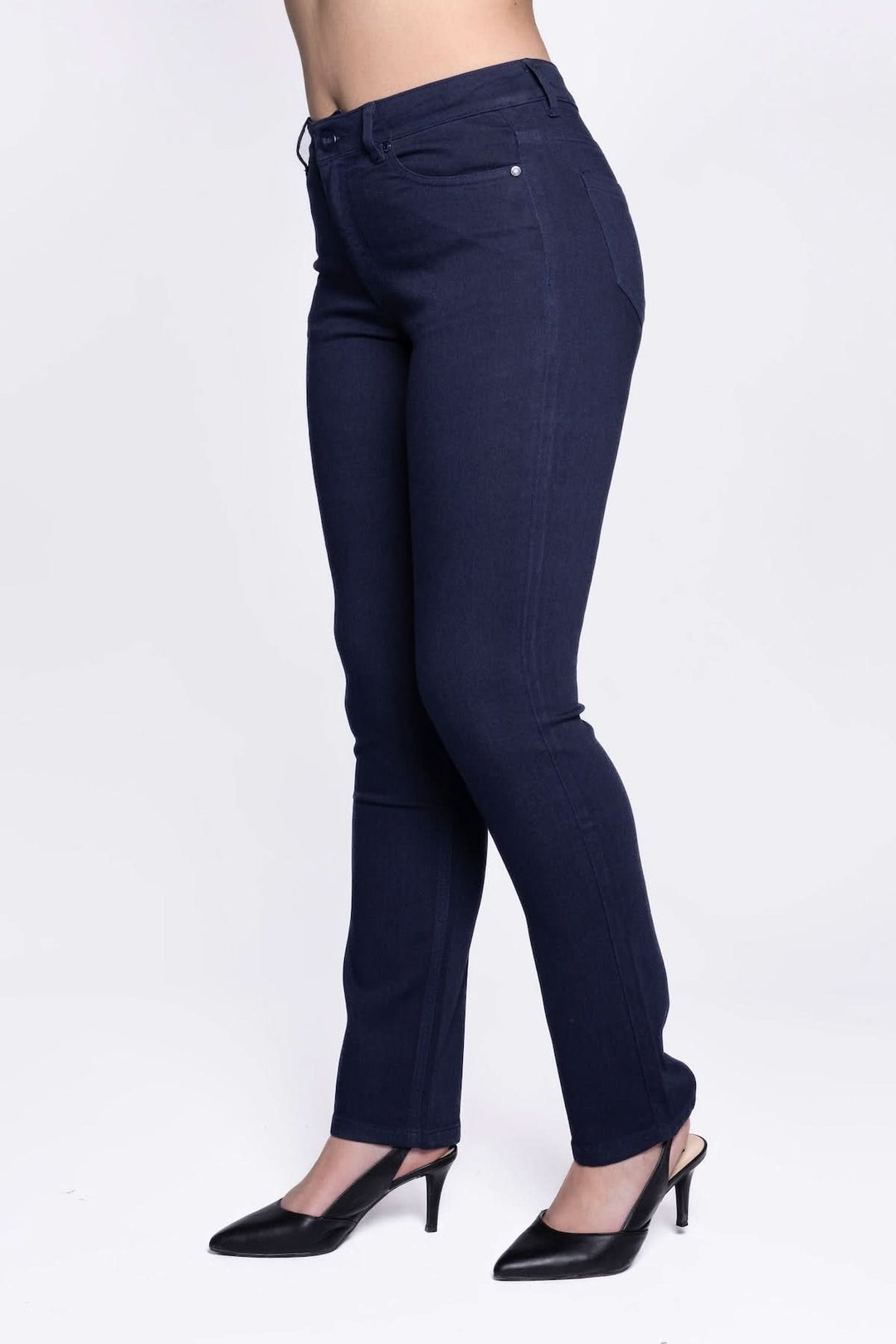 Jean slim à taille mi-haute en denim extensible avec coupe ajustée, porté avec des escarpins noirs, style décontracté élégant.