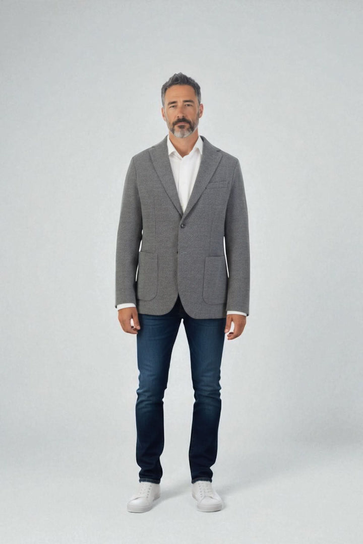 Homme portant un blazer en jersey de coton gris texturé signé Circolo 1901 avec un jean et des baskets blanches, style moderne.