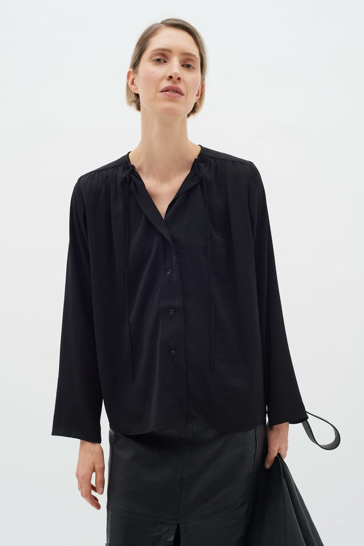 Blouse Mato noire à manches longues avec encolure nouée, idéale pour un look chic.