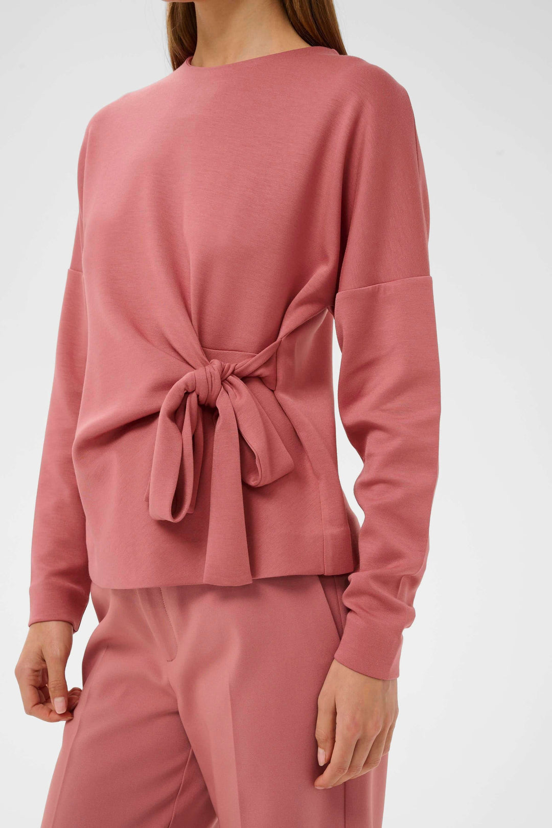 Blouse Tricent avec design noué sur le côté, style contemporain et coupe flatteuse en rose élégante pour un look soigné.