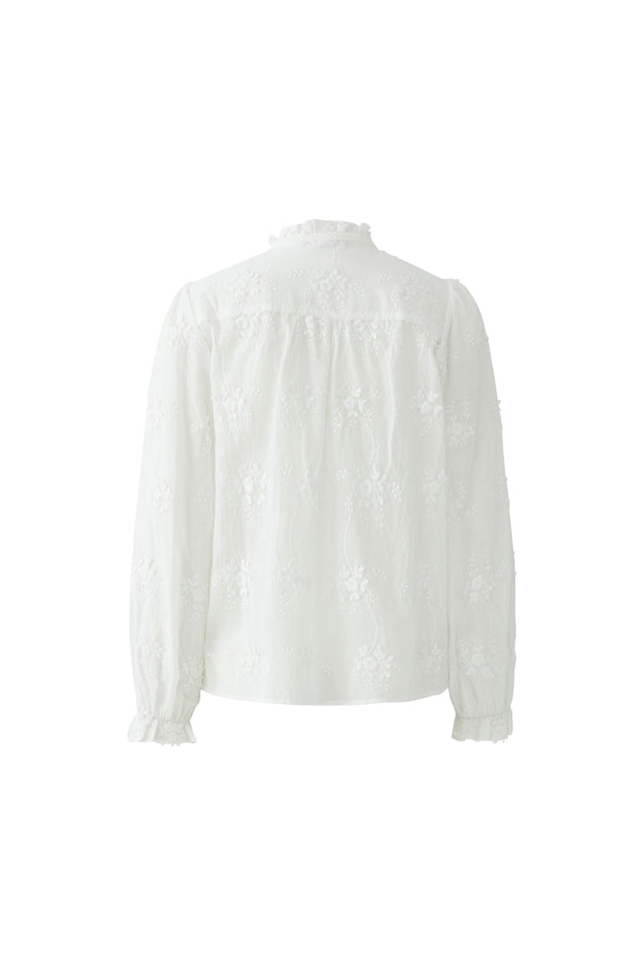 Blouse à broderies florales en dentelle blanche vue de dos, avec col montant froncé et manches longues élégantes.