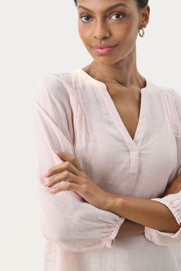 Blouse en lin Nyara, légère et élégante, avec col rond et manches 3/4, présentée sur modèle.