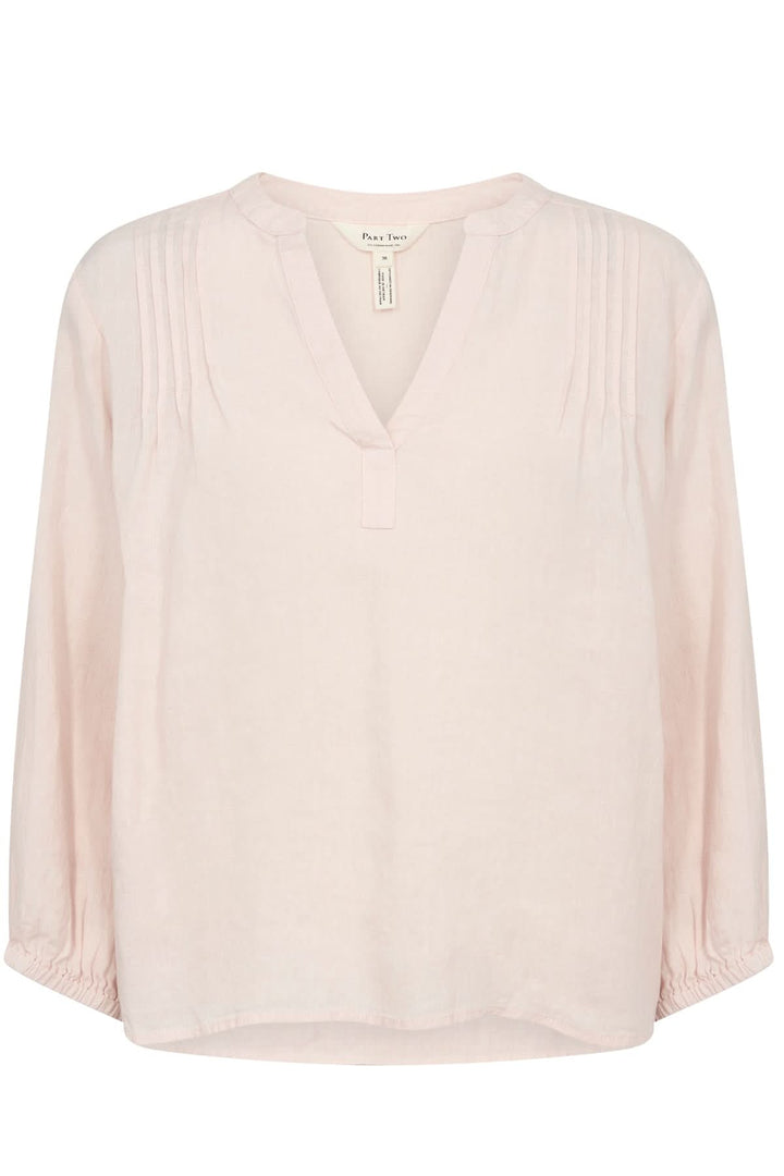 Blouse en lin Nyara coloris rose clair avec décolleté en V et manches 3/4 élastiques.