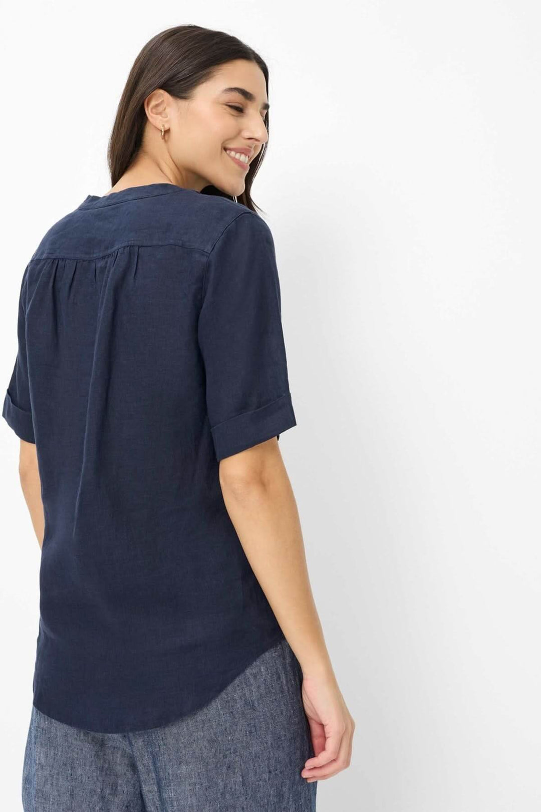 Blouse en lin VERI avec manches courtes et encolure ouverte vue de dos sur modèle féminin, design épuré et confortable.