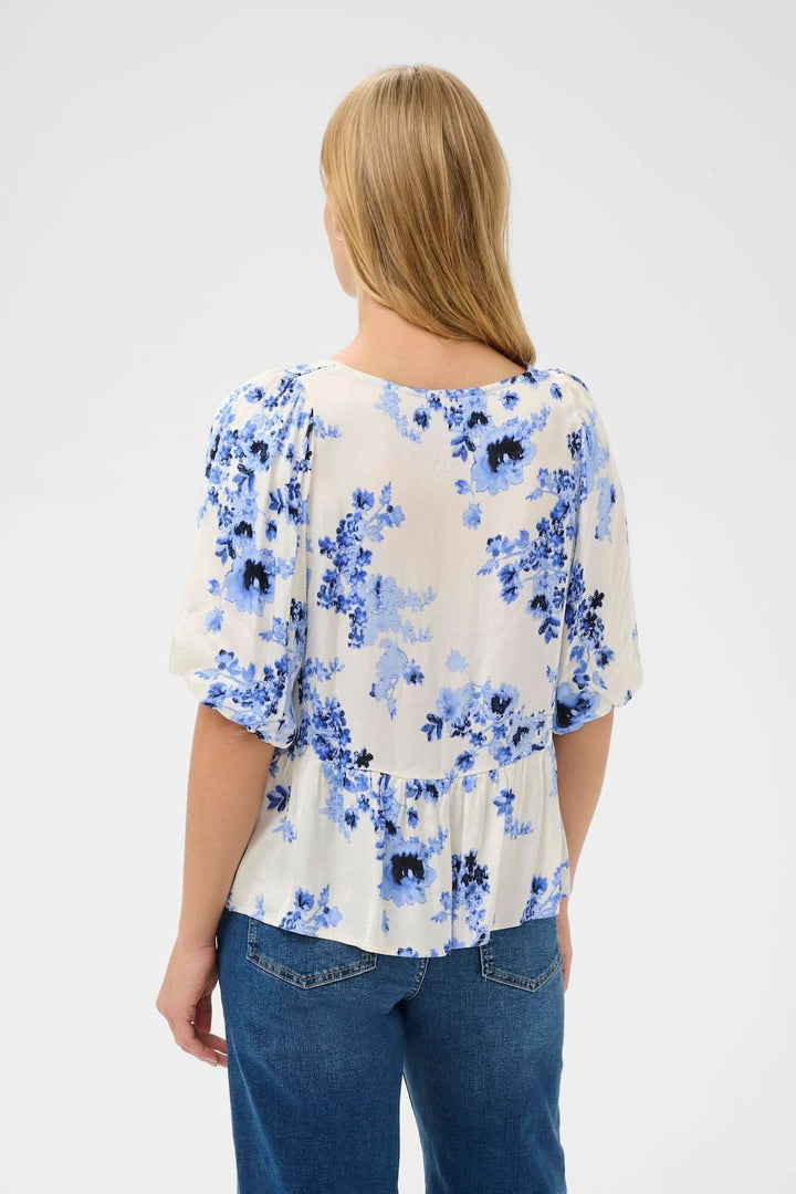 Vue arrière du Blouse fleurie Azelia avec imprimé floral bleu, coupe légèrement évasée et taille froncée pour un style féminin et fluide.
