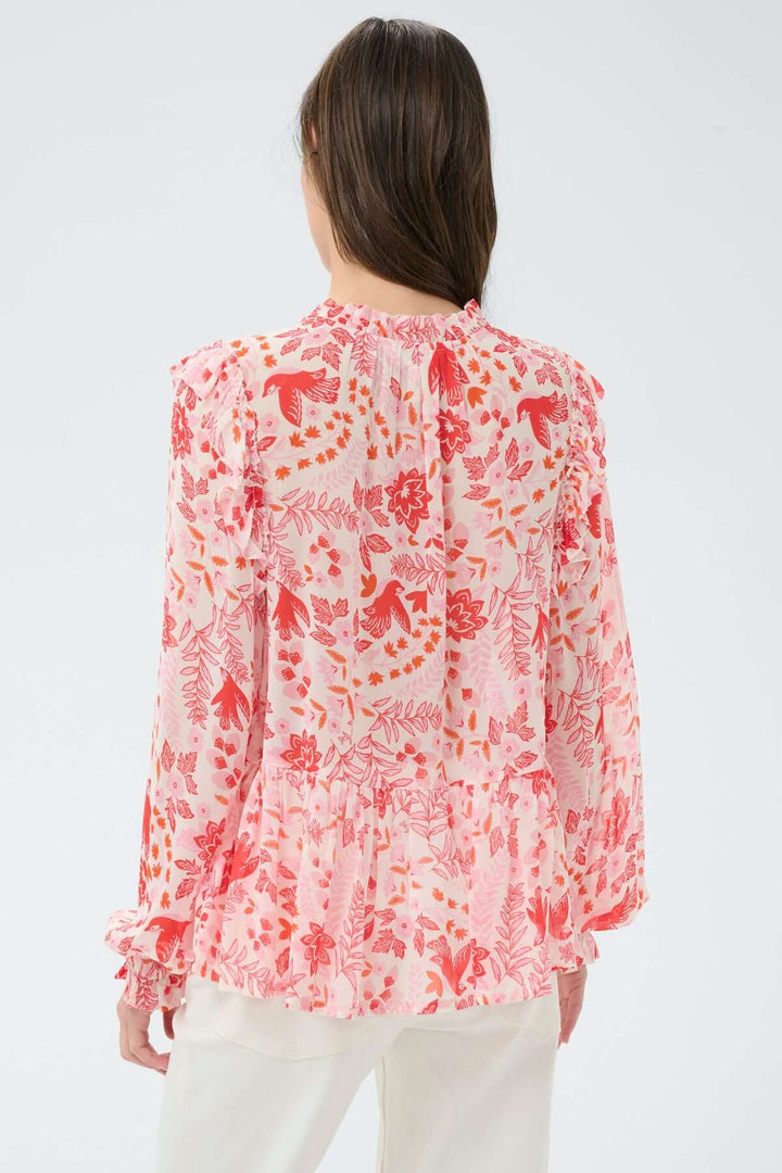 Femme portant une blouse fluide à encolure fendue Alfrida avec imprimé délicat et coupe légère, vue de dos, couleur rose et blanc.