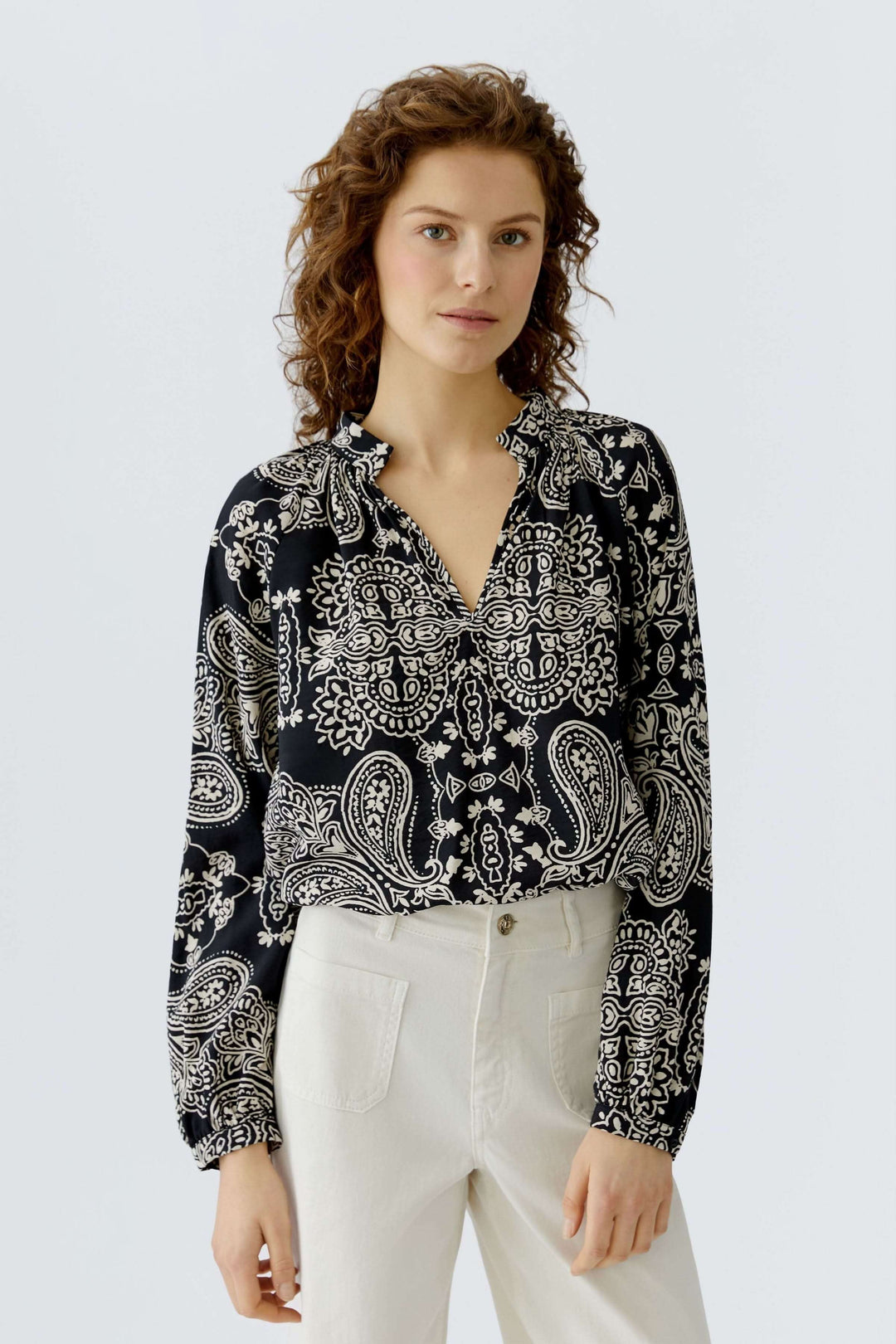Blouse fluide imprimé graphique bohème avec encolure ouverte et coupe droite, portée par un mannequin.