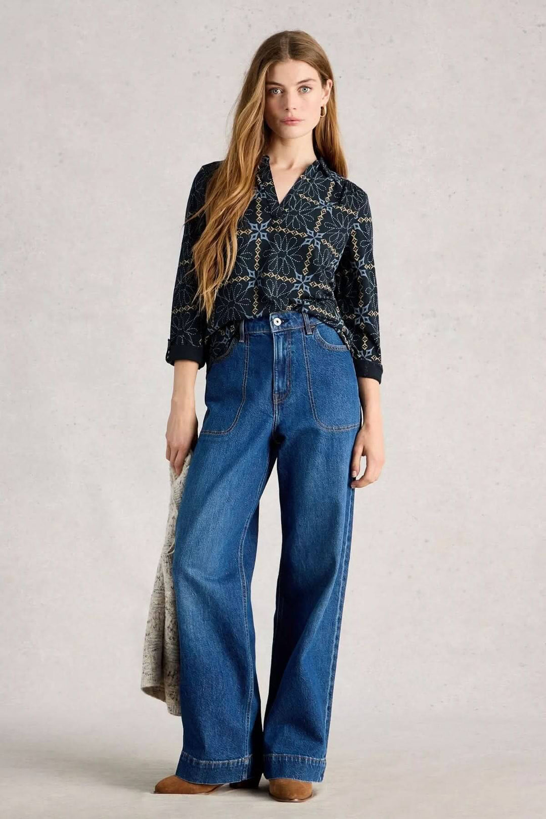 Femme portant la blouse imprimée manches trois-quarts Allie avec un jean ample, style élégant pour le bureau et le quotidien.