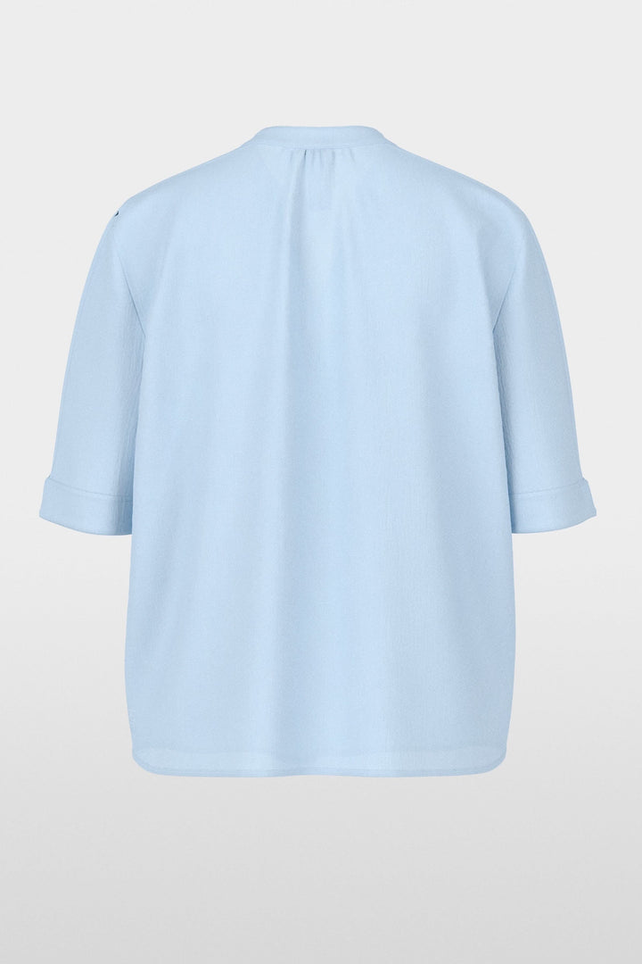 Blouse à manches courtes en bleu avec encolure en V et manches à revers, coupe fluide et élégante, vue arrière sur fond blanc.