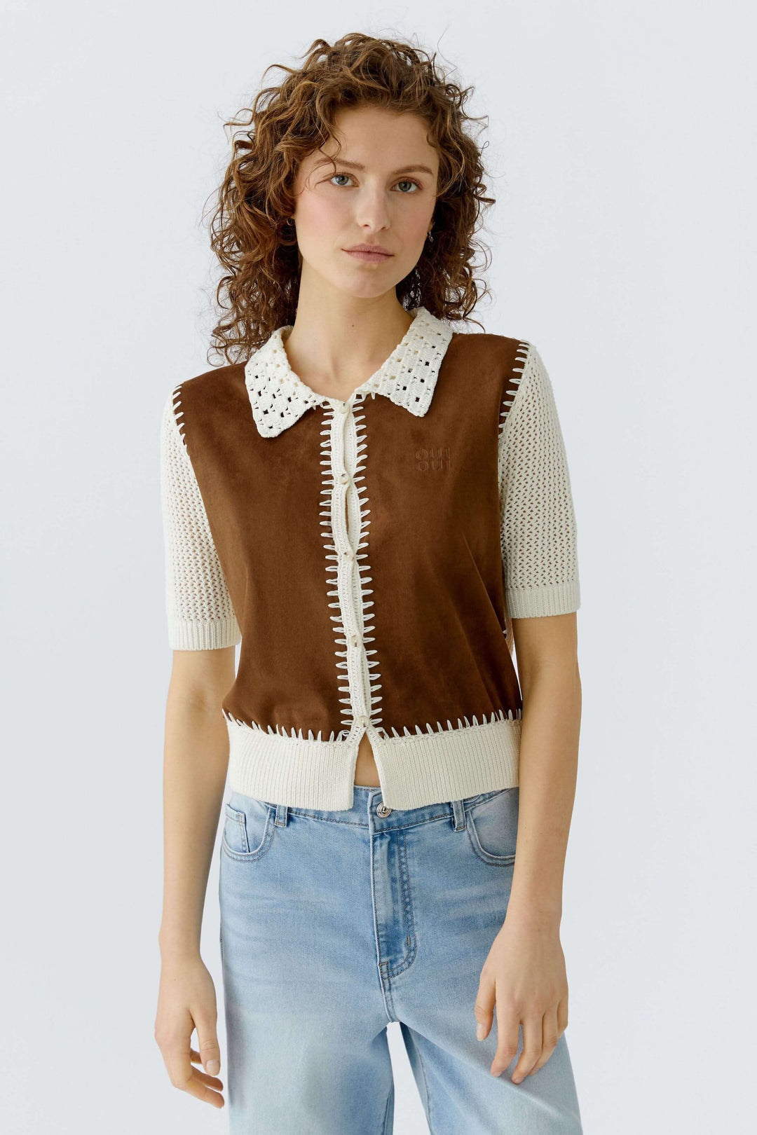 Blouse manches courtes avec jeu de matières et col ajouré, détails décoratifs, pour un look artisanal et raffiné.