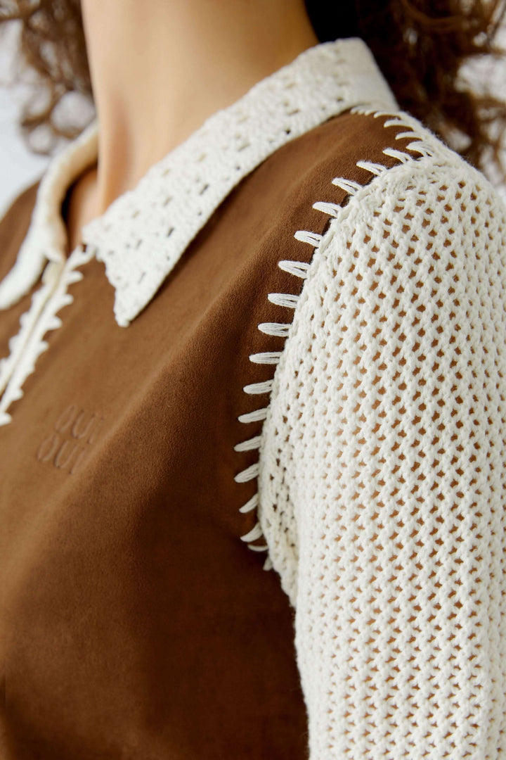 Blouse manches courtes avec col ajouré et finitions artisanales sur mannequin.