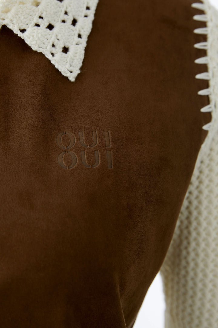 Blouse manches courtes avec col ajouré et détails décoratifs contrastants en gros plan.