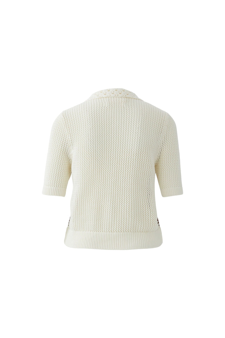 Blouse manches courtes en tissu texturé avec col ajouré et détails artisanaux, vue arrière. Décris moi le produit en français.