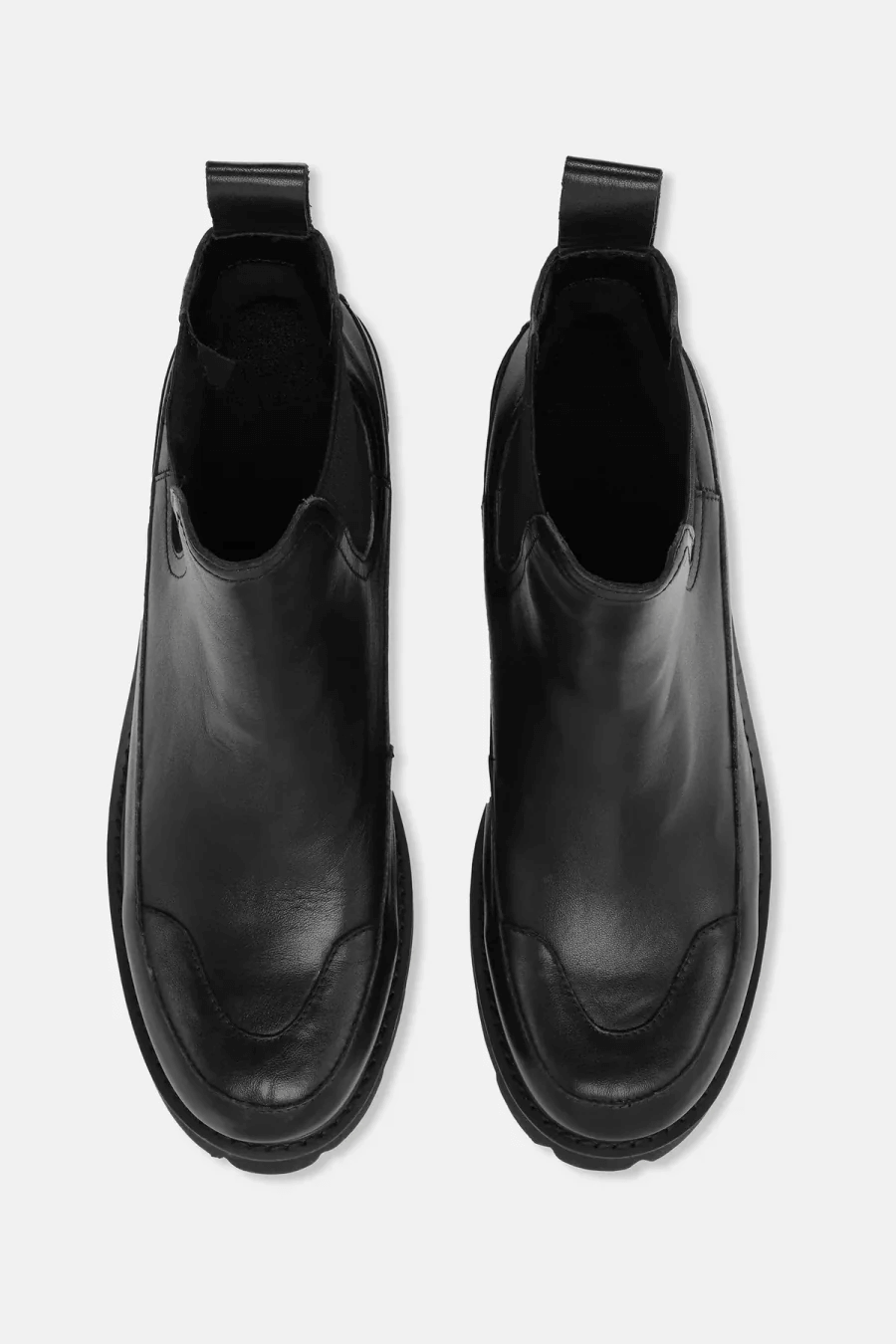 Bottes Chelsea noires en similicuir avec semelle crantée, modernes et robustes pour un style urbain.