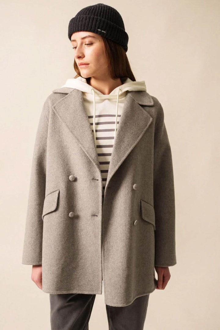 Femme portant le Caban STE ELINA en laine avec col tailleur et boutons blason, style nautique élégant et poches pratiques.