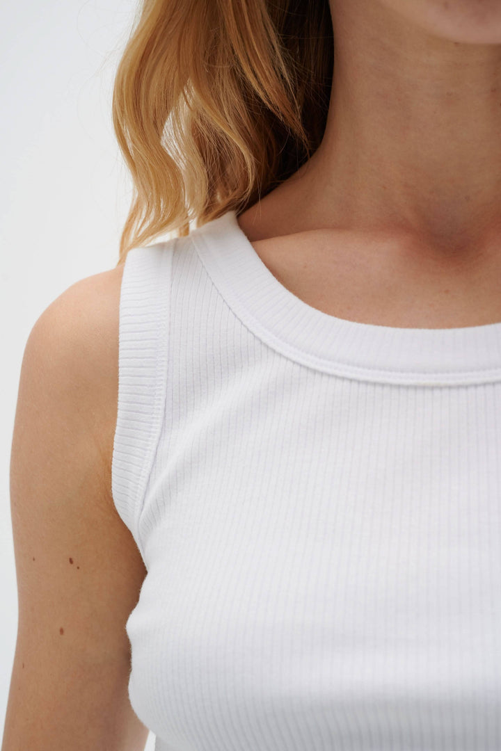 Camisole Dagna en coton côtelé blanc, ajustement minimaliste, encolure ronde et bretelles larges.
