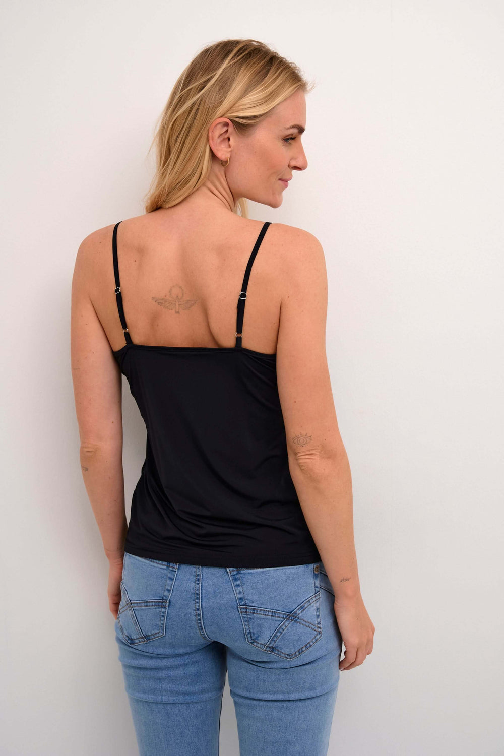 Femme portant la Camisole Lissandra avec fines bretelles et coupe ajustée, vue arrière, contre un fond blanc.