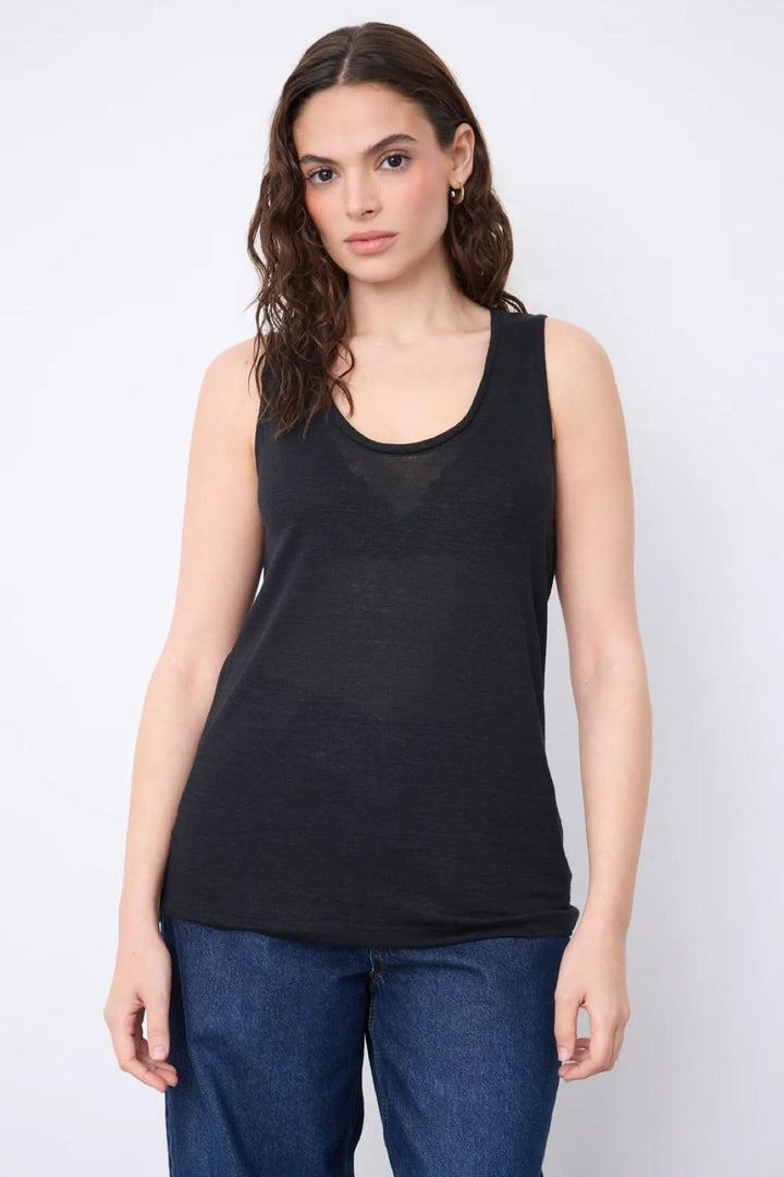 Femme portant une Camisole Yana en maille légère noire, sans manches et à encolure arrondie, idéale pour la saison chaude.