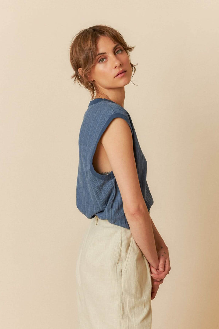 Camisole ample sans manches avec encolure ronde, portée par un modèle féminin au style décontracté.