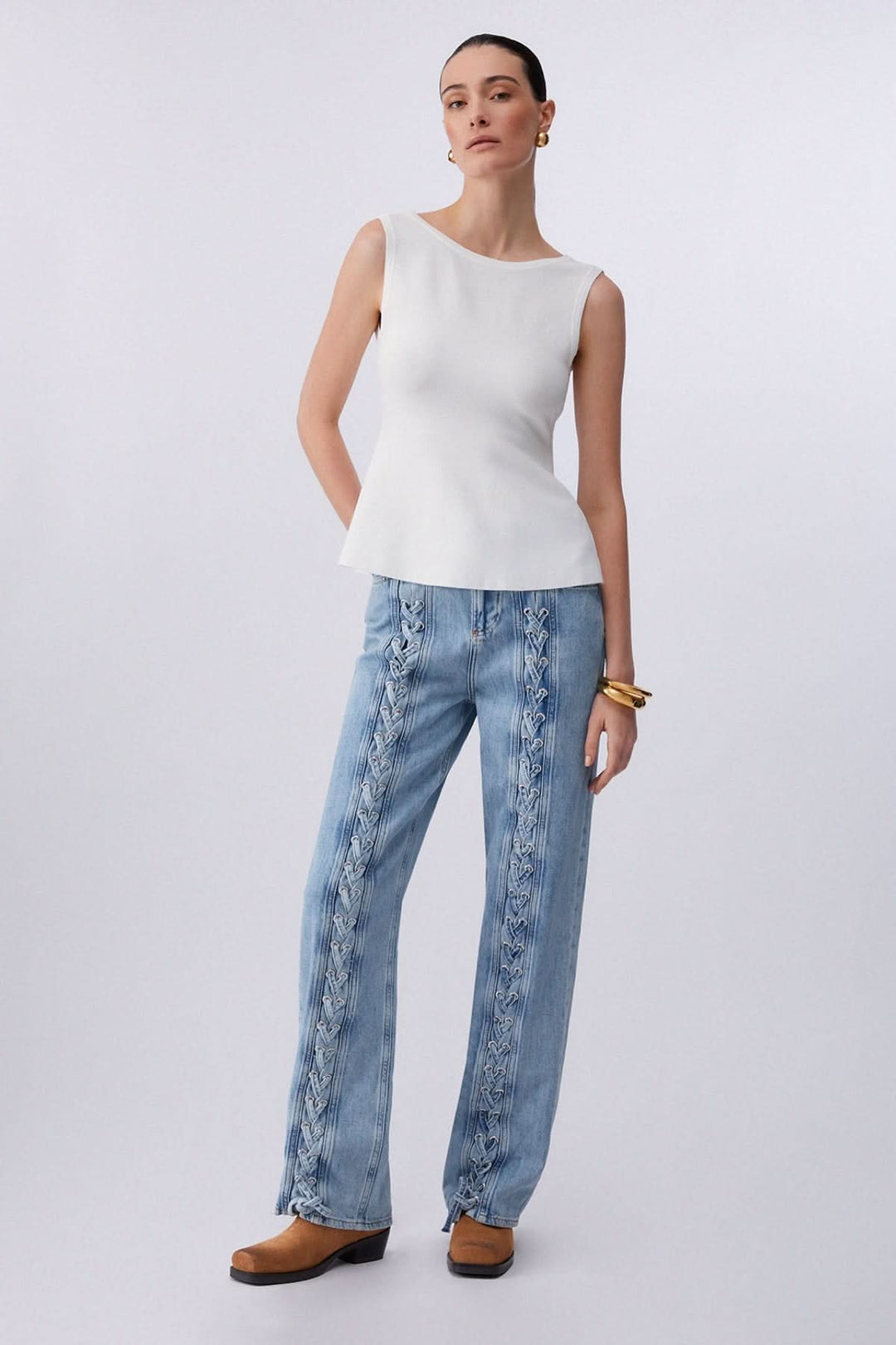 Femme portant une camisole fluide avec dos ouvert et nœud, tenue élégante et moderne idéale pour superposition ou journées chaudes.