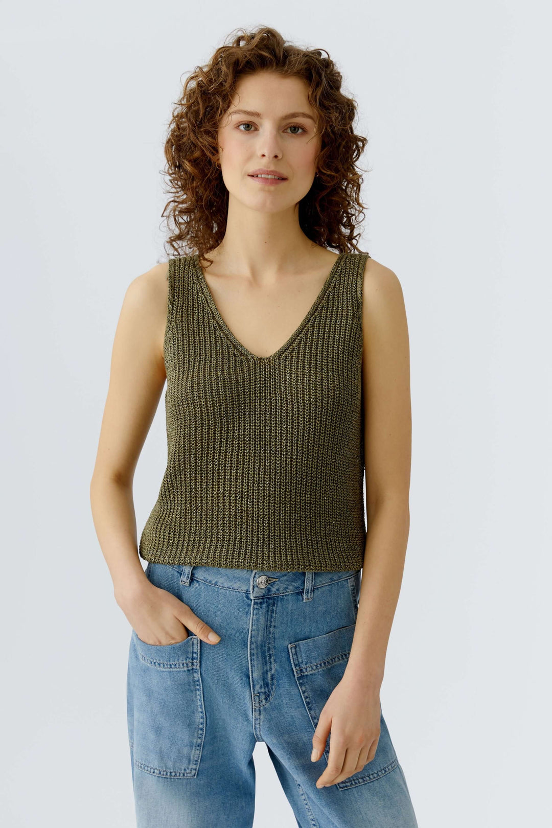Femme portant une camisole tricoté en fil spécial avec encolure en V, idéale pour superposition et style décontracté.