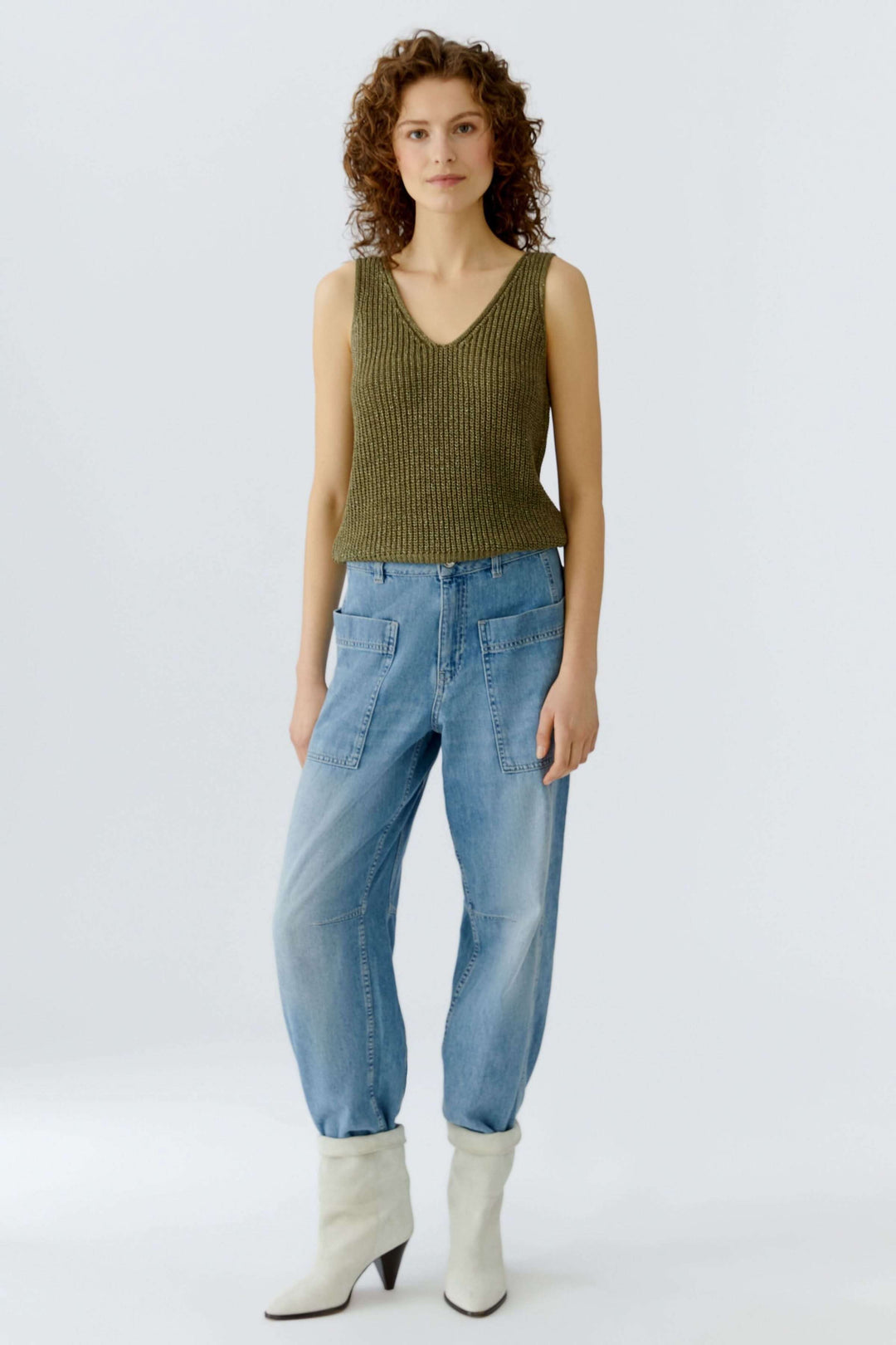 Camisole tricoté en fil spécial avec encolure en V, coupe droite, idéale pour superposition, portée par une femme debout.