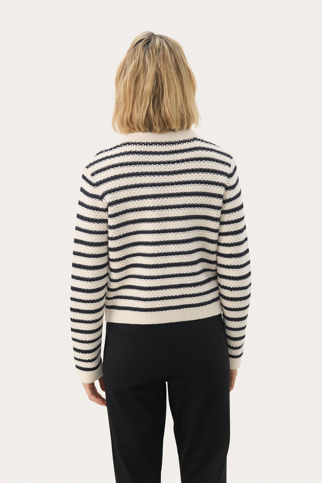 Femme portant le cardigan Elmie à rayures horizontales, coupe droite, tricot texturé, vue de dos, style élégant et moderne.