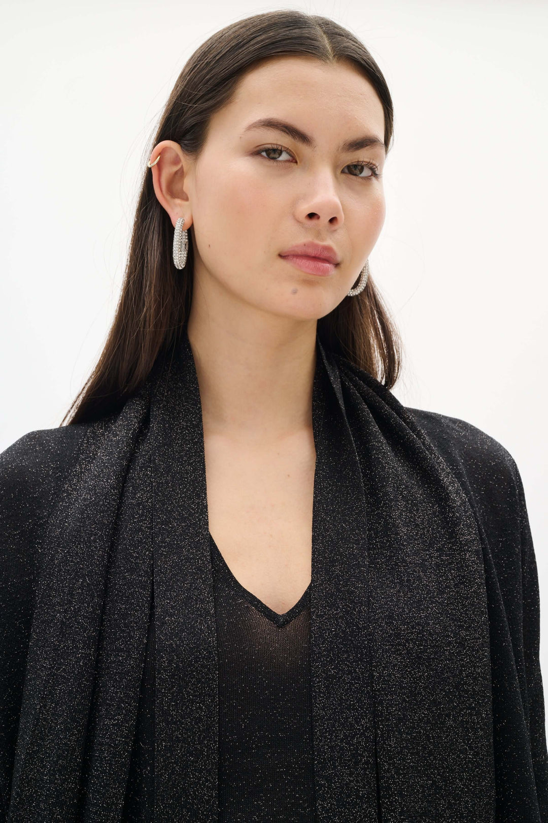 Modèle portant le Cardigan Thani à effet scintillant avec foulard intégré, ajoutant une touche élégante et sophistiquée à la tenue.