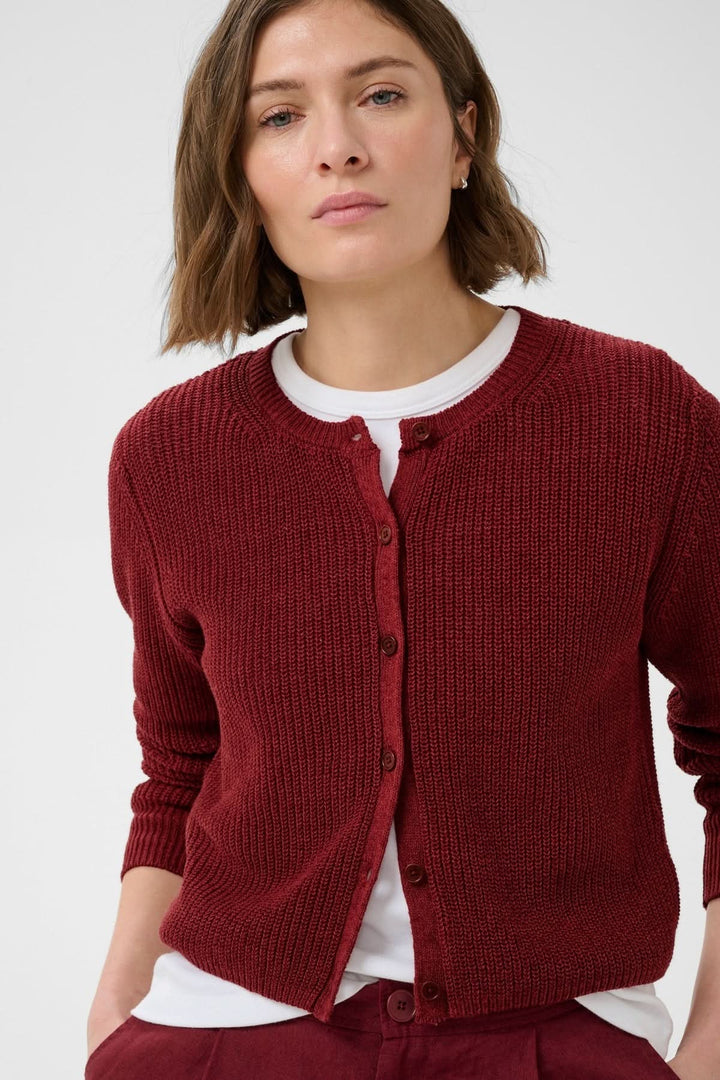 Femme portant le cardigan boutonné Gigia en maille texturée rouge, style décontracté avec encolure ronde et fermeture boutonnée.