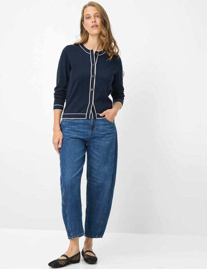 Femme portant un Cardigan boutonné à col contrasté ANN avec jeans, allure élégante et décontractée.