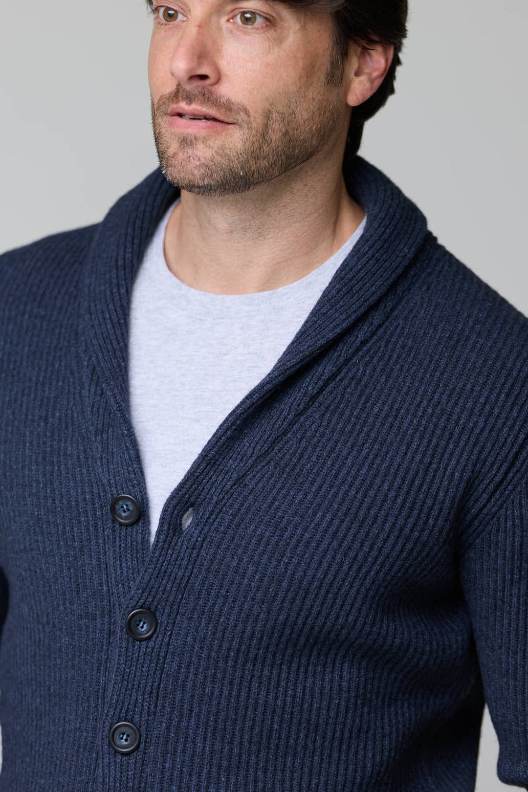 Homme portant un cardigan à col châle en laine bleu marine boutonné.
