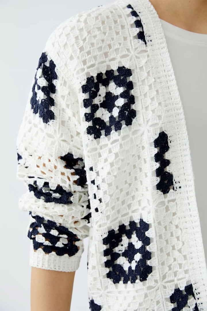 Cardigan en crochet blanc avec motifs géométriques marines, parfait pour un look bohème et élégant.