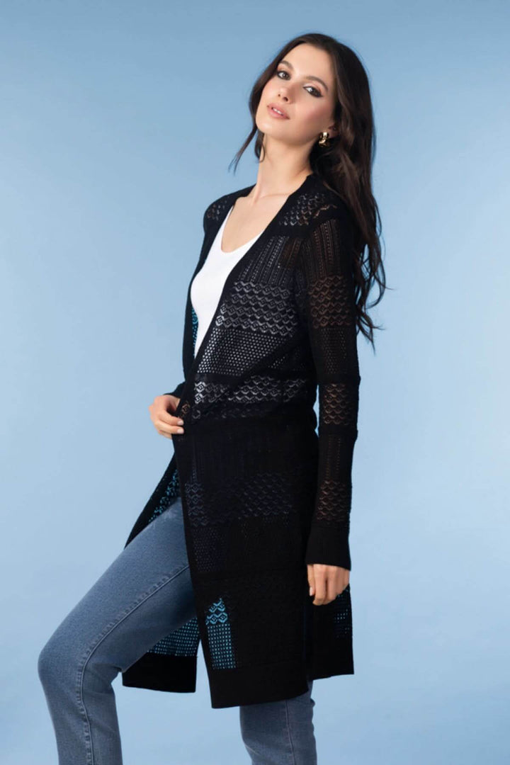 Cardigan long en maille ajourée porté par une femme, parfait pour un look élégant et léger.