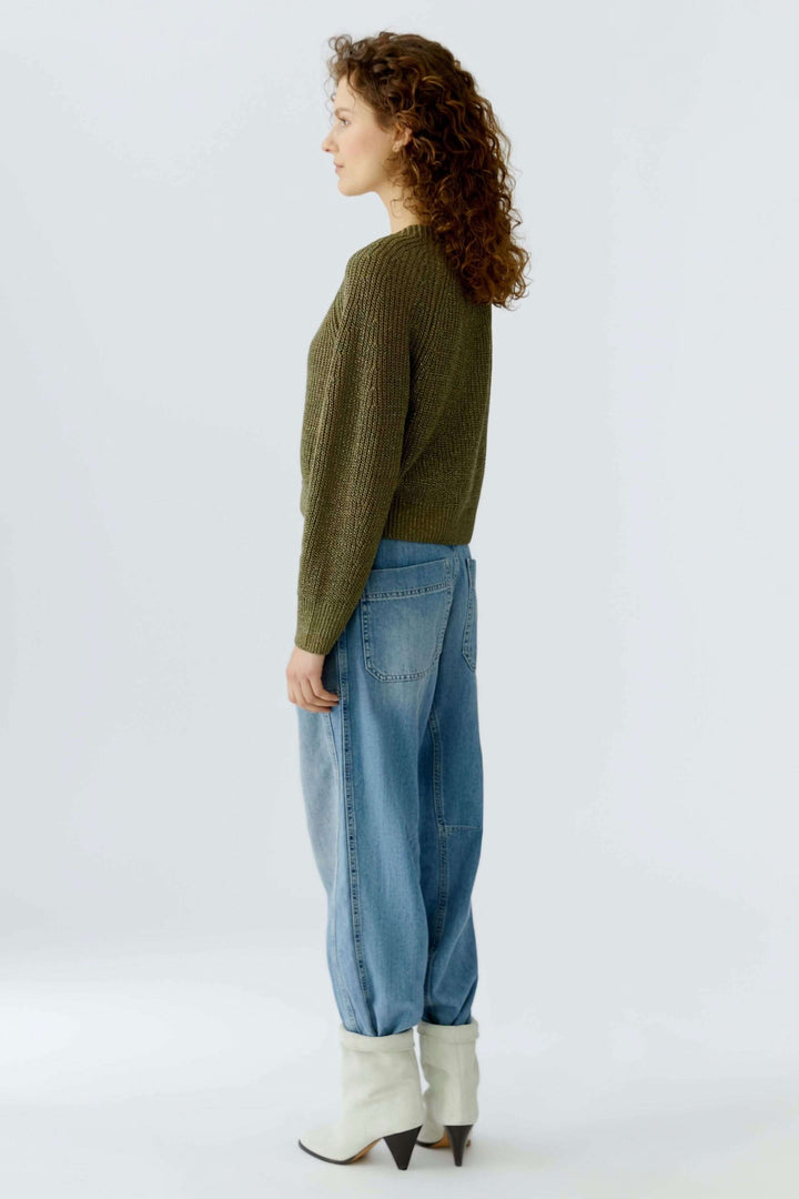 Femme portant un cardigan tricoté, coupe courte, en maille élégante avec encolure en V et fermeture boutonnée classique.