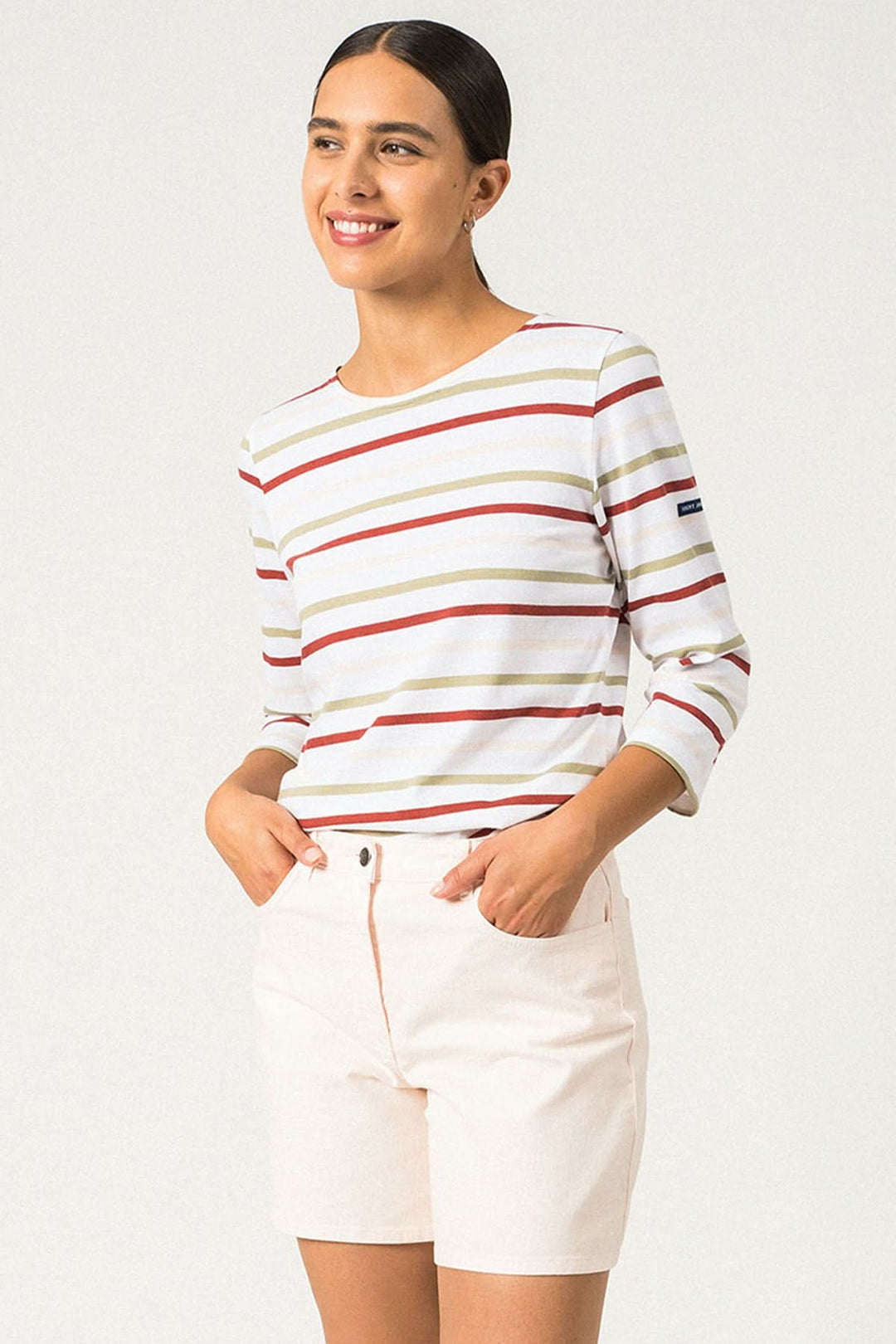 Femme souriante portant un chandail rayé GALATHEE II avec manches ¾ et short beige, style décontracté.