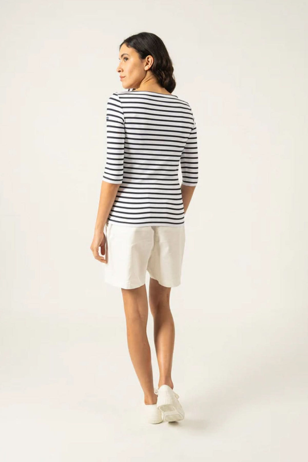 Femme portant un chandail Garde-Côte III R à rayures, vue arrière, avec manches 3/4 et shorts blancs.