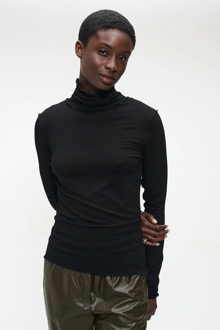Chandail Janice noir ajusté avec col roulé, moderne et épuré, porté avec élégance pour un look minimaliste et chic.