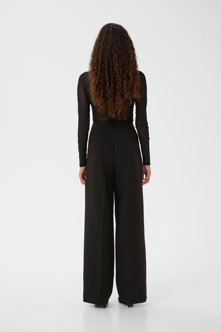 Dos du modèle portant le Chandail Kaia en tulle transparent à manches longues, affichant une silhouette moderne et élégante, idéal pour superposition.