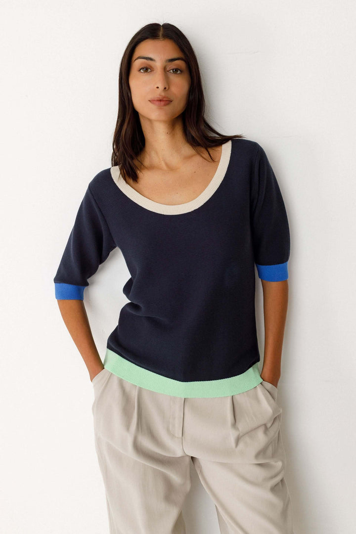 Femme portant le Chandail Lary tricot léger col rond manches courtes en bleu avec détails contrastants, style décontracté et moderne.