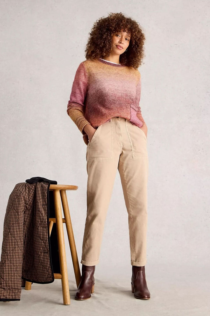 Femme portant un Chandail Lilbet dégradé avec poche kangourou, associé à un pantalon clair, sur fond neutre.