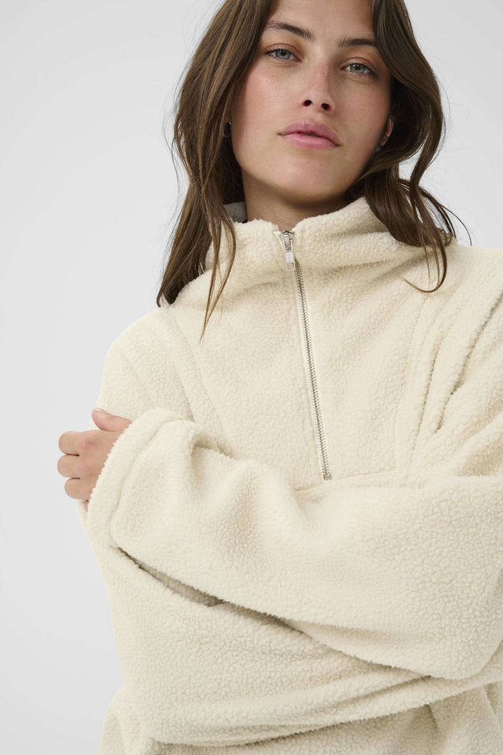 Chandail Sirana en tissu effet sherpa avec col montant zippé pour style cosy et confort en mi-saison.