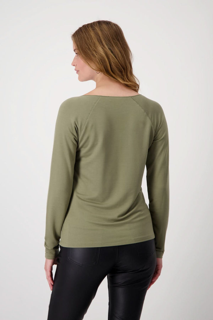 Femme portant un chandail basique vert olive, vue de dos, coupe légèrement cintrée avec manches longues raglan.