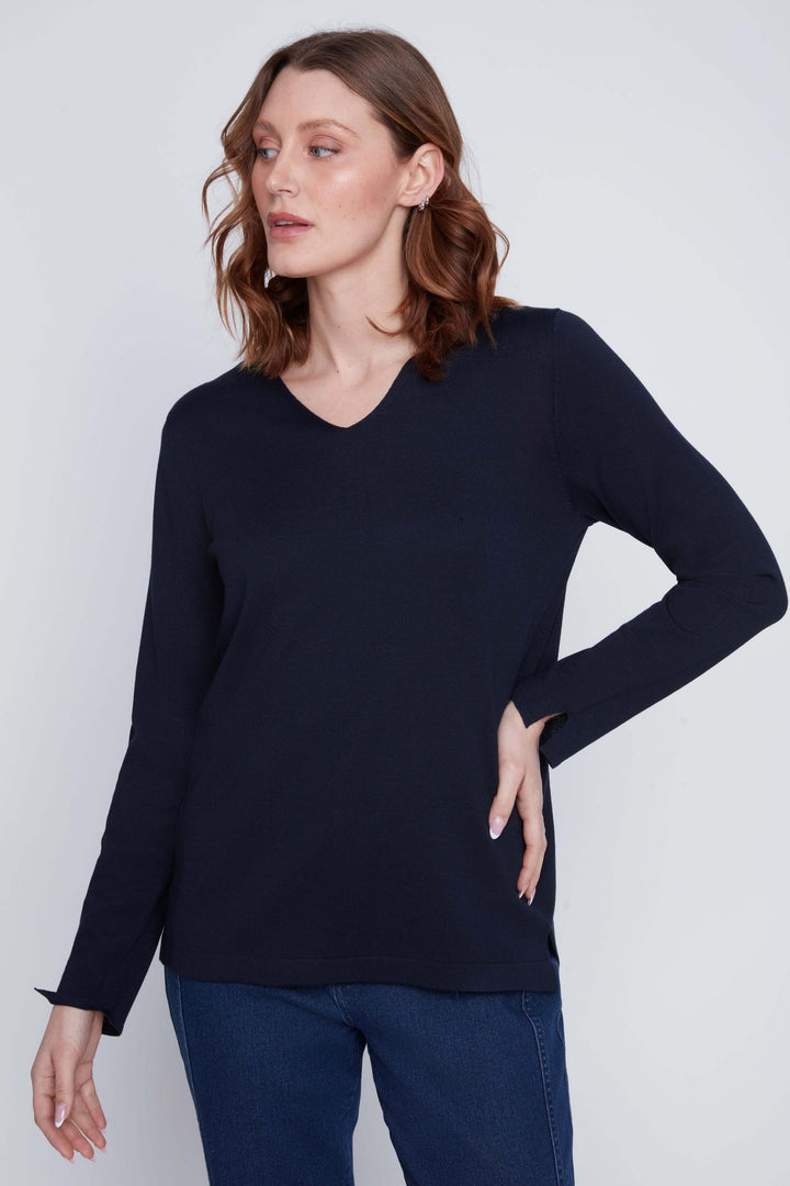 Femme portant un Chandail col V bleu marine manches longues, coupe droite et fluide, style minimaliste.