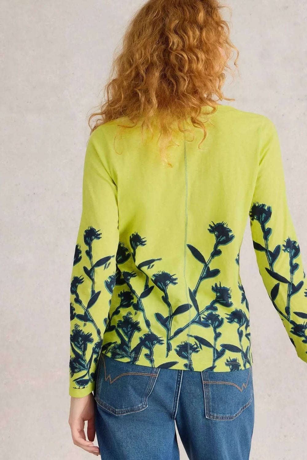 Chandail à col cranté Nelly, imprimé floral subtil sur fond jaune, porté avec un jean.