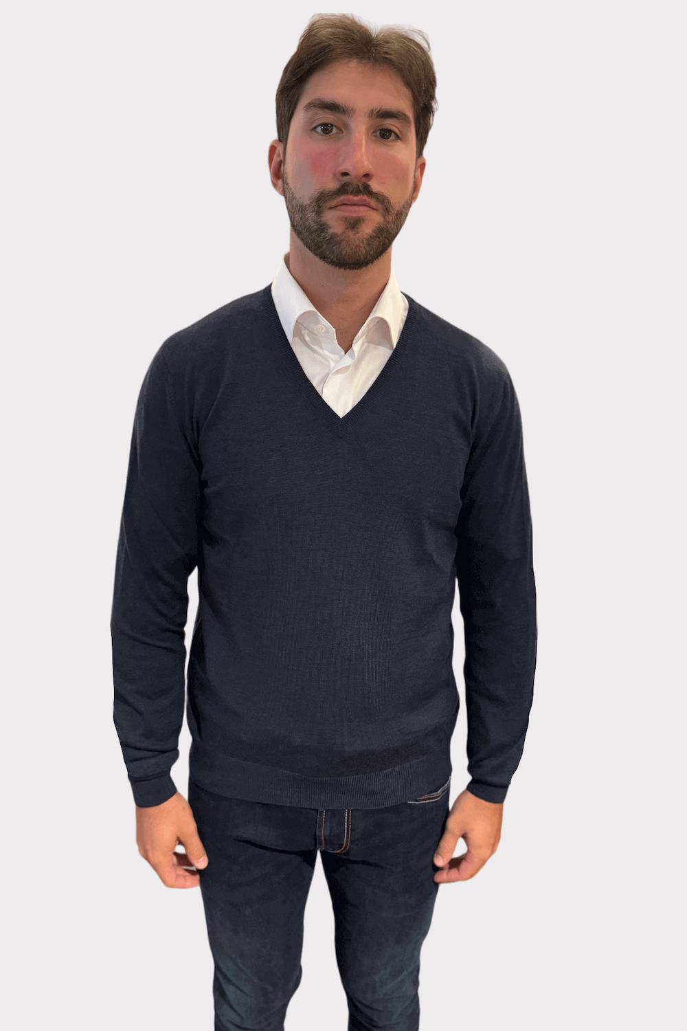 Pull en V en laine pour hommes, style élégant et confortable, porté avec une chemise blanche.